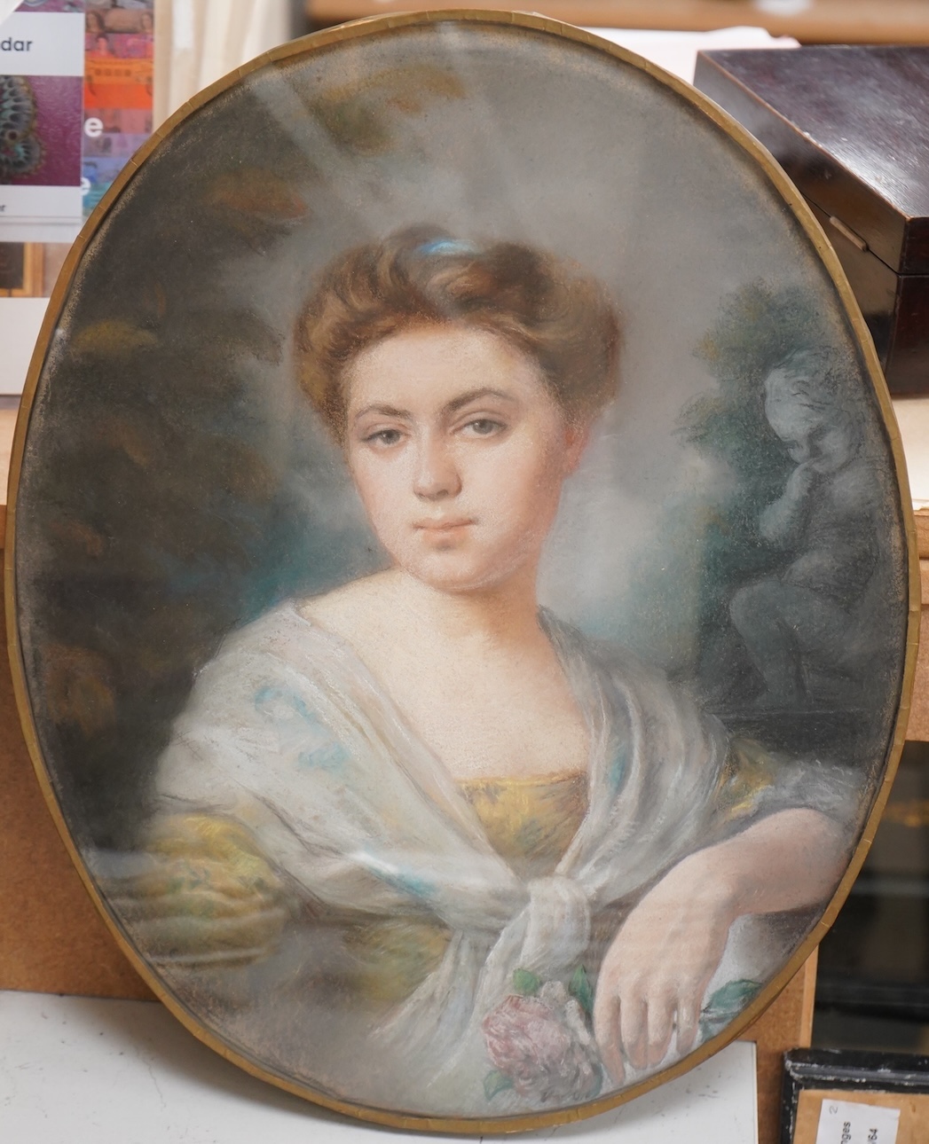 Late 18th century School, Portrait of a young lady holding a rose, oval pastel, 40 x 33cm